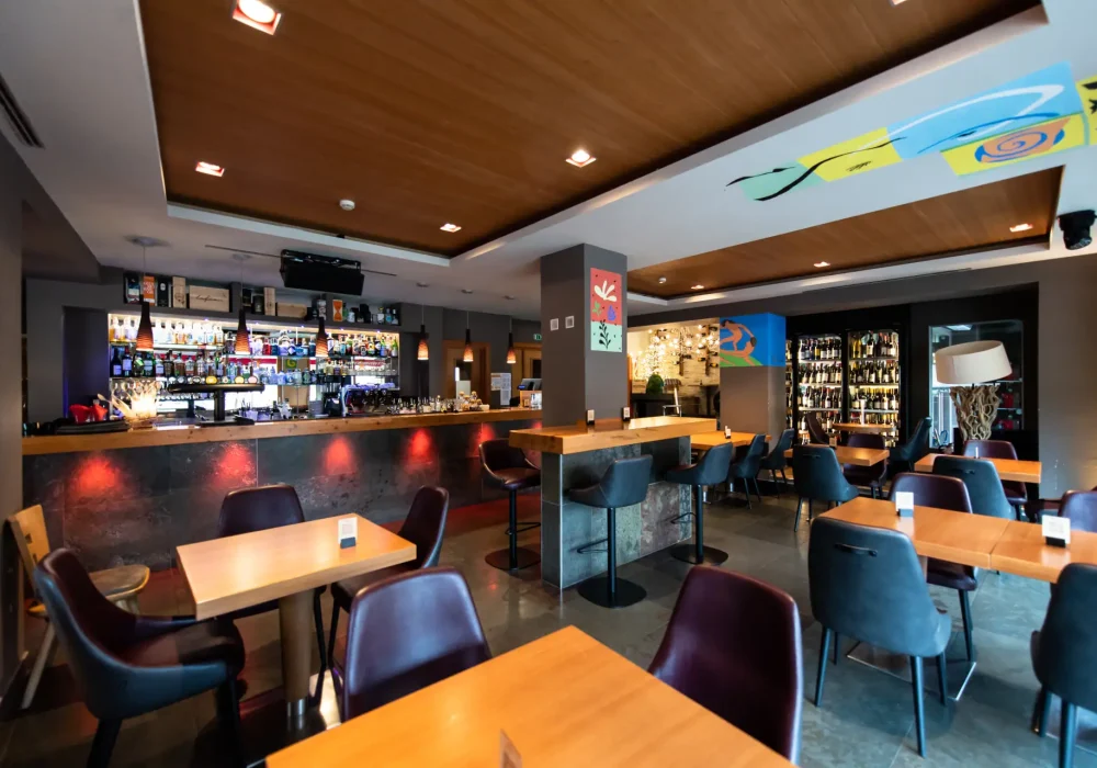 Un moderno bar con tavoli di legno e sedie imbottite. Un moderno bar con tavoli di legno e sedie imbottite.